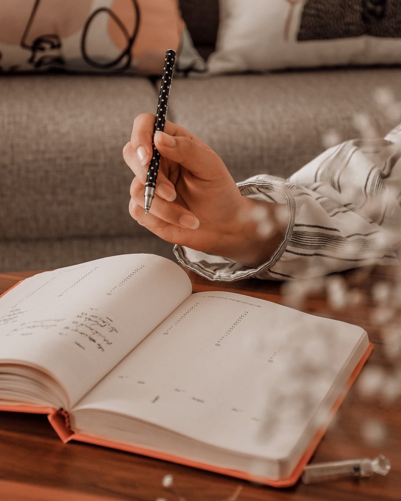 Young person writing memo in planner